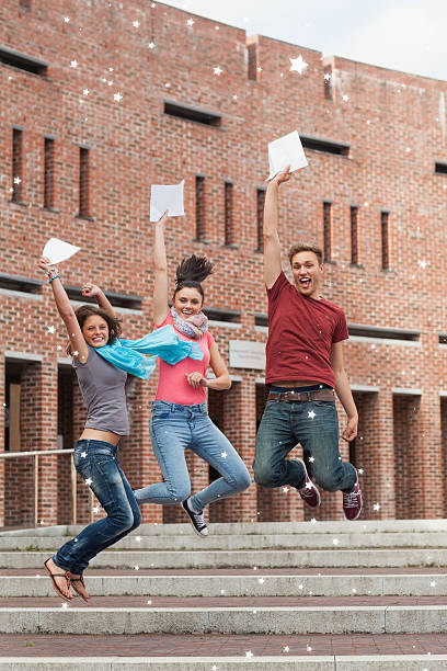 istock Happy students jumping in the air holding exam 524029739