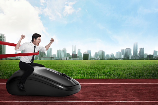 Asian business person riding computer mouse. Business technology concept