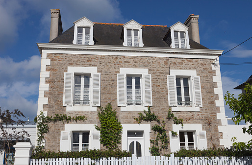 Saint-Malo, France - July 7, 2011: Villa built with traditional granite stones and french doors in Rotheneuf, a suburb of Saini-Malo. Rotheneuf is a seaside resort and famous for its sculpted rocks.