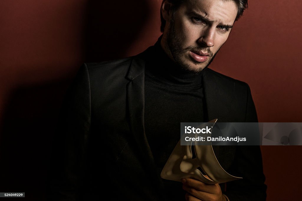 mask off handsome man holding a mask Men Stock Photo