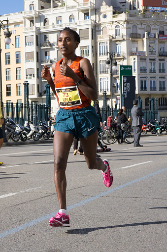 Valencia, Spain - November 16, 2014: Woman runner Alem Fikre Kifle of Ethiopia competes in the 2014 Valencia Marathon.  Kifle finished in 5th place (women division) with a time of 2:34:09.