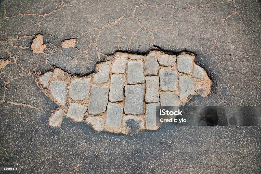 Pothole 02 Aerial view of a pothole in an asphalted road that let exposed the antique paving in Rosario city, Argentina Abandoned Stock Photo