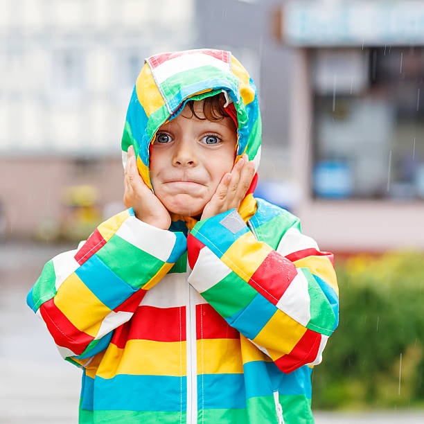 istock Funny smiling little boy walking in city through rain 524068307
