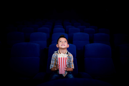 Happy boy at the cinema watching a movie