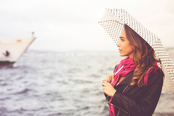 Woman waiting for ferry boat on Boshorus Istanbul, Turkey.