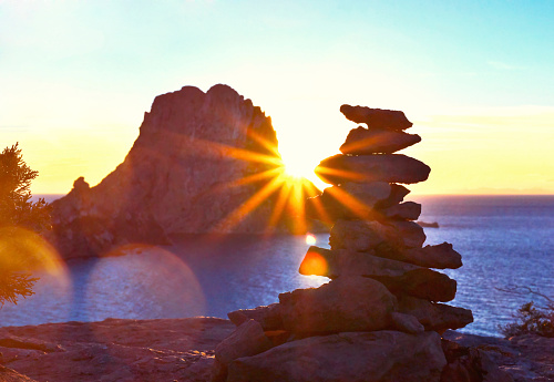 Sunset at es Vedra, Ibiza Island. Evening sun shining through the isle of es Vedra and an esoteric stack rock.