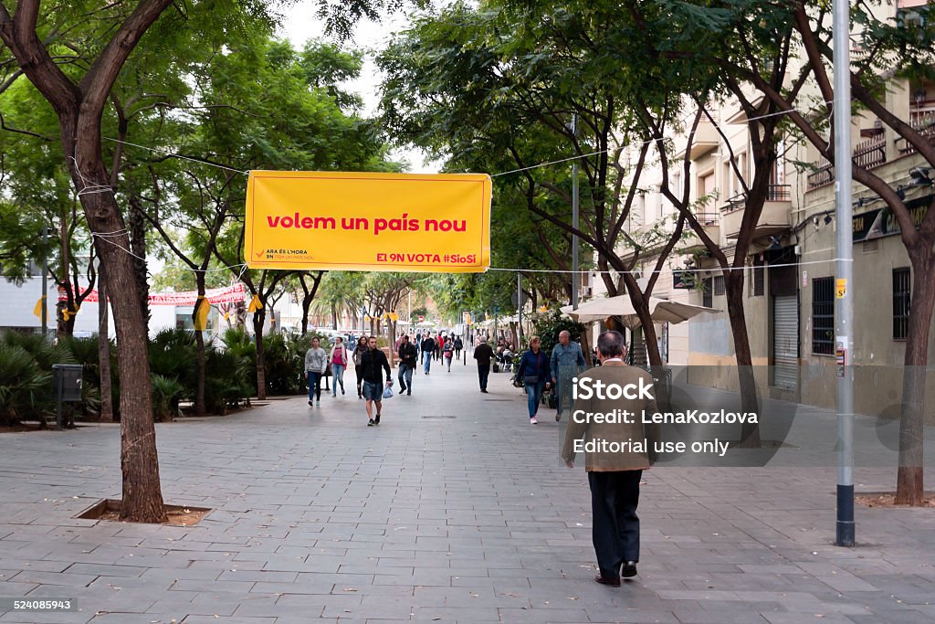 Day of voting for independence of Catalonia Barcelona, Spain - Novembre 09, 2014 : people are walking at the street where is situated a poster where is written " we want one new country" in Barcelona. Adult Stock Photo