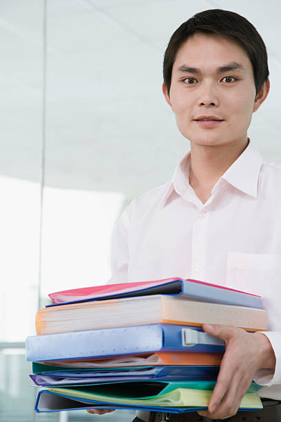 istock Businessman holding stack of files, smiling, portrait 524087243
