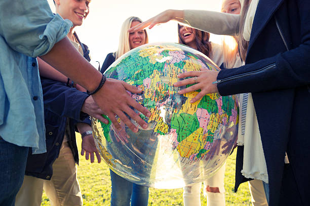 istock Group of young people holding a world globe 524087667
