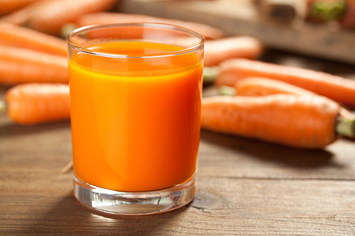 Close up of carrot juice on old wood table. This file is cleaned and retouched.