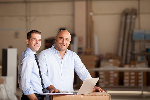 Two businessman working in factory.