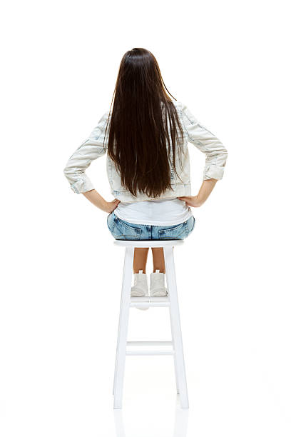 istock Rear view of woman on stool looking away 524090643
