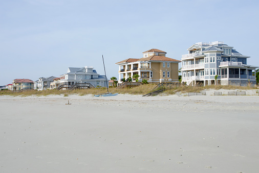 A row of oceanfront, upscale, beach houses. Taken just after sunrise with beautiful light and sky.