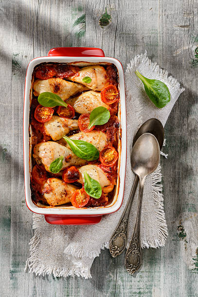 Baked chicken drumsticks with tomato sauce and green salad stock photo