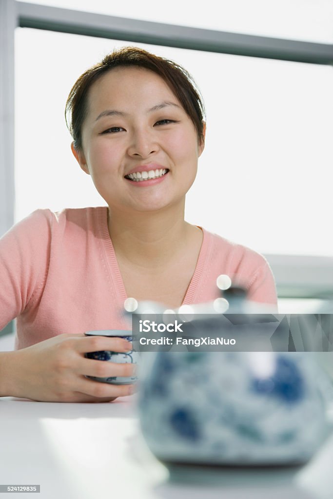 Young woman holding tea cup, smiling, portrait 20-24 Years Stock Photo