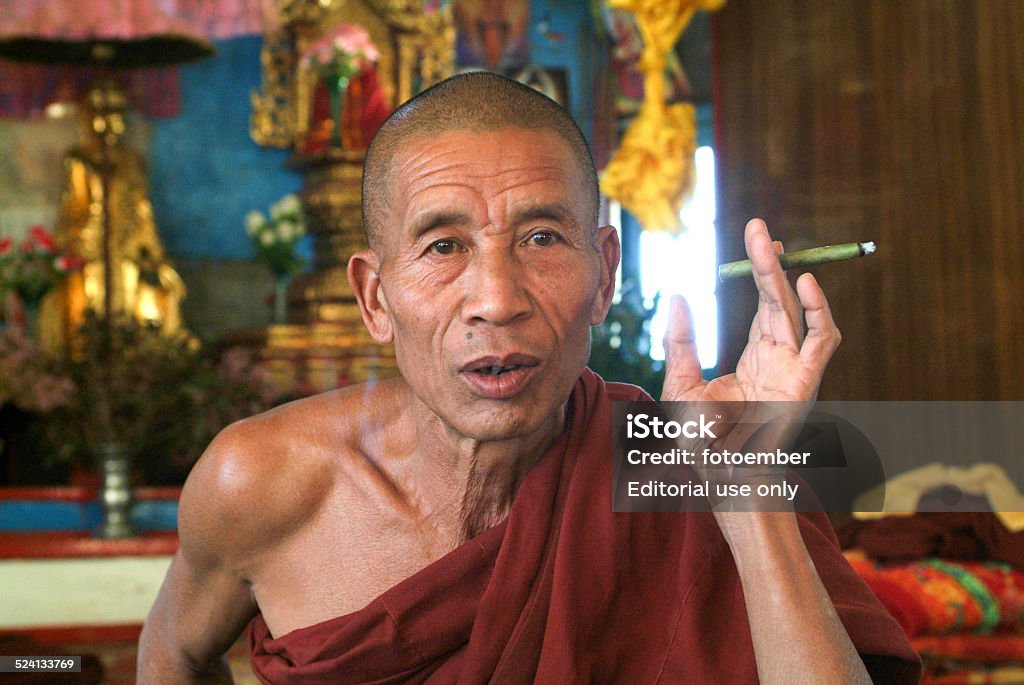 Monk smoking at the monastery of the village of Joate Joate (Kalaw), Myanmar - 12 January 2010: Monk smoking at the monastery of the village of Joate on the mountains over Kalaw on Myanmar Asia Stock Photo