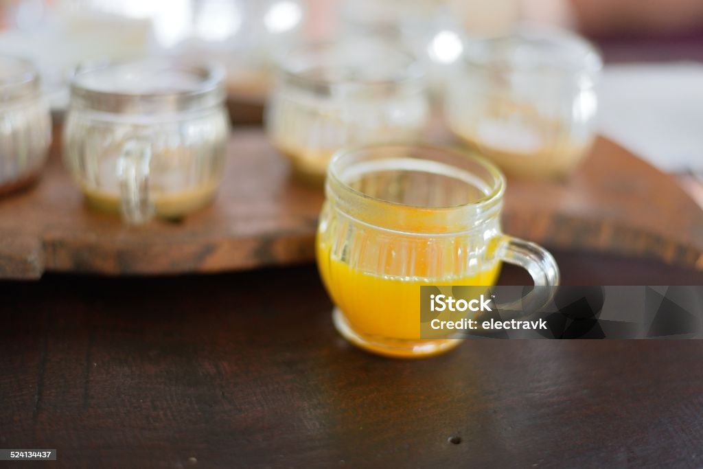 Turmeric tea A small cup of brightly colored turmeric tea. More drinks can be seen in the background. Bali Stock Photo