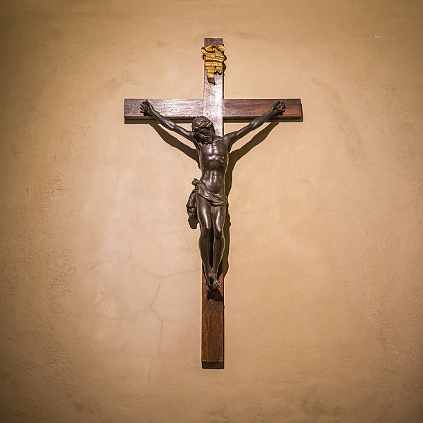 Crucifix on wall in spotlight. Jesus Christ on cross. Religion, belief and hope. Holy and sacred places.
