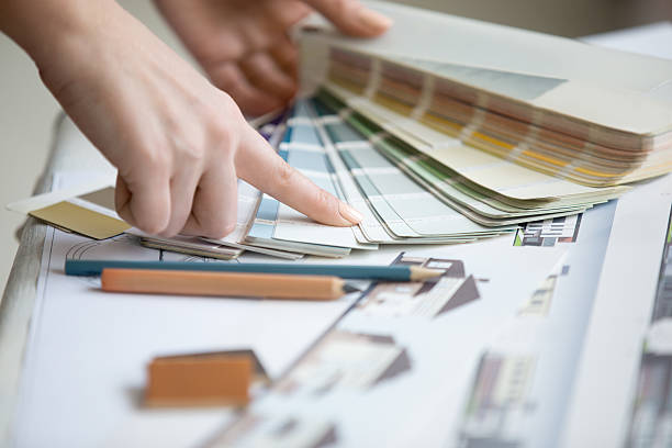 Young designer working with color palette Creative people workplace. Close-up view of hands of young designer woman working with color palette at office desk. Attractive model choosing color samples for design project. Interior shot interior designer stock pictures, royalty-free photos & images