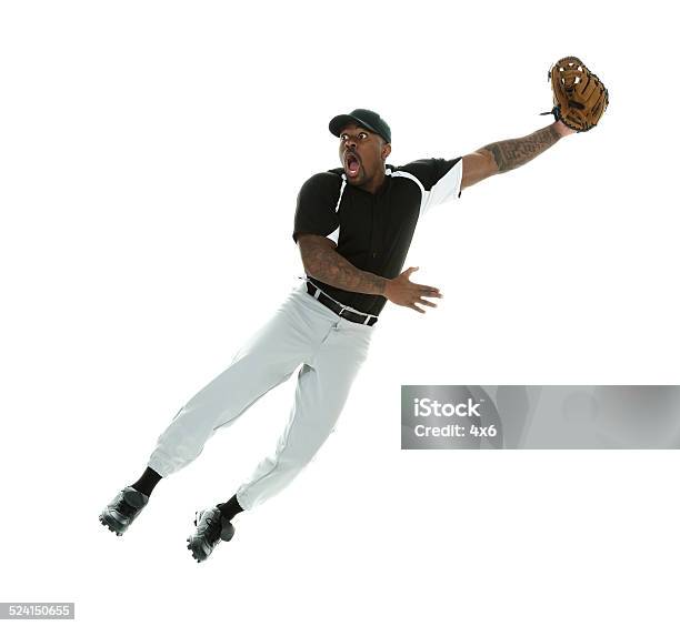 Shocked Baseball Player Jumping Catching The Ball Stock Photo - Download Image Now