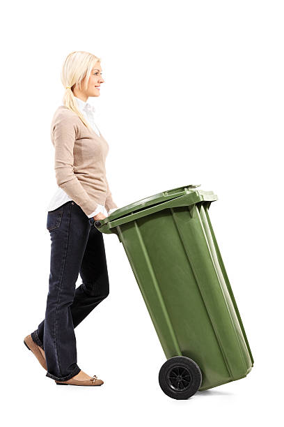 istock Cheerful young woman pushing a garbage can 524150695