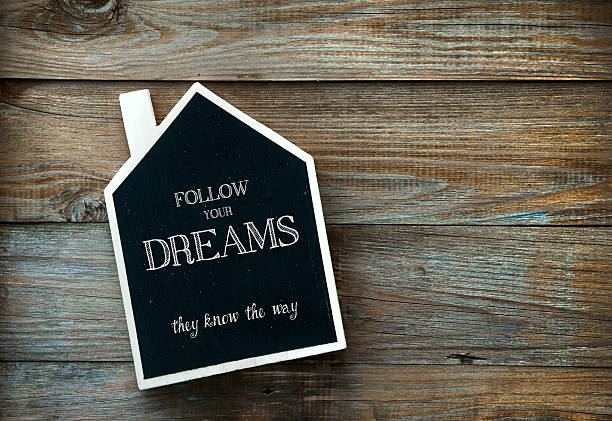 istock House Shaped Chalkboard sign on rustic wood Follow your dreams 524151629