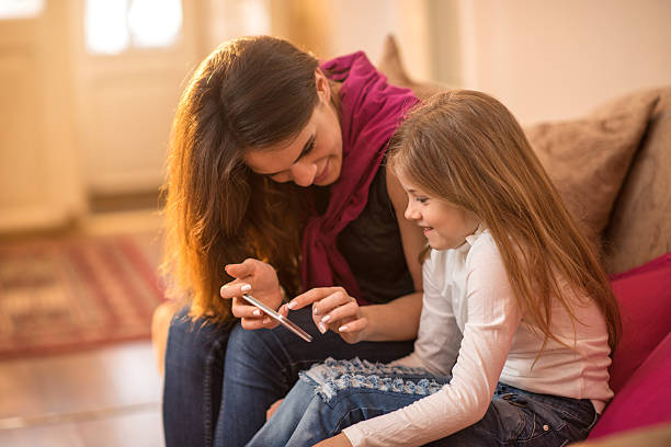 istock Smiling mother and daughter looking something on cell phone. 524152590