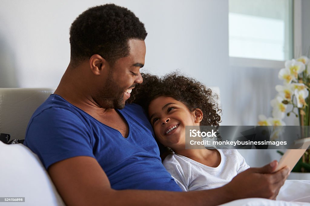 Black father and daughter relaxing in bed look at Black father and daughter relaxing in bed look at each other Child Stock Photo