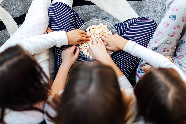 Hands In Bowl Full Of Popcorn
