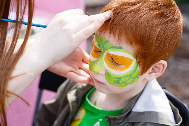 istock Child face painting process at redhead boy 524158140