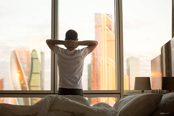 istock Young man watching sunrise in his bedroom 524160718