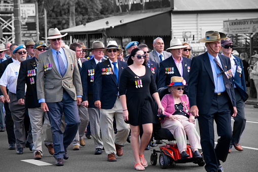 Cooroy, Sunshine Coast Australia - April 25, 2016: A group of Australian Defence Force veterans march through the streets of Cooroy during ANZAC Day.  This image contains a range of ages, genders, civilian clothing and physical ability.