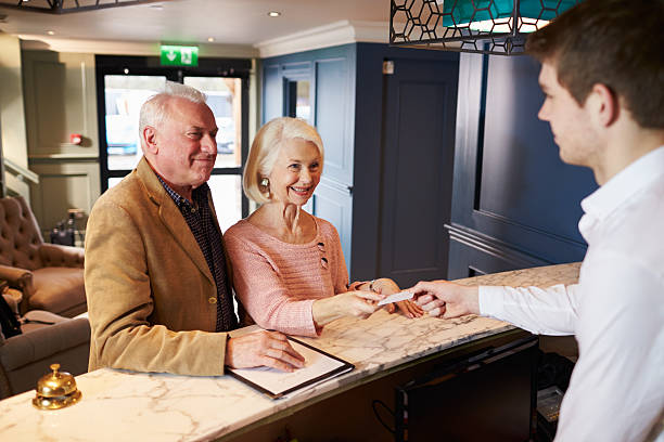 istock Senior Couple Checking In At Hotel Reception 524162922
