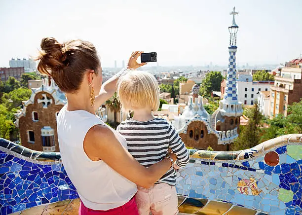 Barcelona will show you how to remarkably spend holiday. Mother and baby taking photos with digital camera at Park Guell