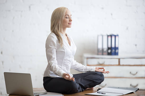 geschäftsfrau meditieren in ihrem büro - zen like meditating yoga business stock-fotos und bilder