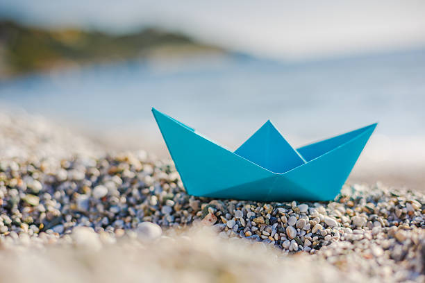 istock Blue paper boat on the beach 524165518