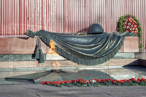 Moscow, Russia - April 10, 2015: The Unknown Soldier tomb with the Eternal Flame and blurred pinks before. 