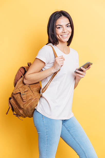 istock Smiling woman with backpack holding smartphone 524166108