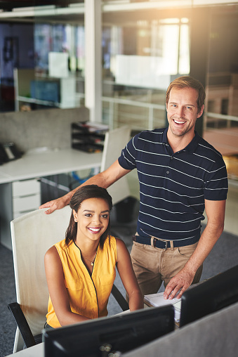 Portrait of two smiling colleagues working together in an office