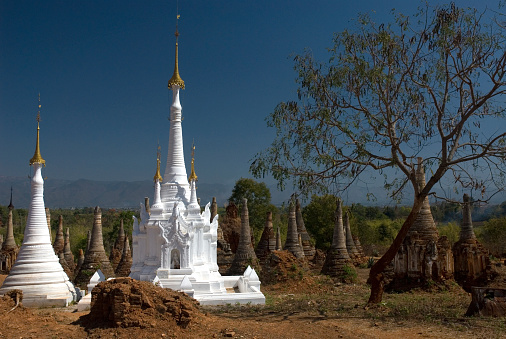 Restore white Pagoda between Crazy Pagodas in Shwe Inn Thein Paya, Indein, (Nyaungshwe), Inle Lake,Shan state, myanmar (Burma). Weather-beaten buddhistic zedi constructed in 17th and 18th century damaged by earthquake in 1975.
