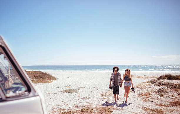 hipster pareja caminando juntos hacia van a pies descalzos en la playa - couple old fashioned hipster holding hands fotografías e imágenes de stock