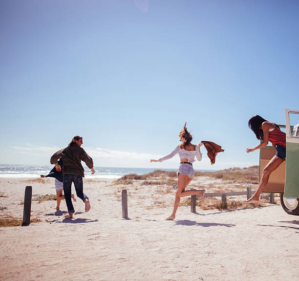 hipster amigos salto de viaje por carretera van en la playa - victoria memorial fotografías e imágenes de stock