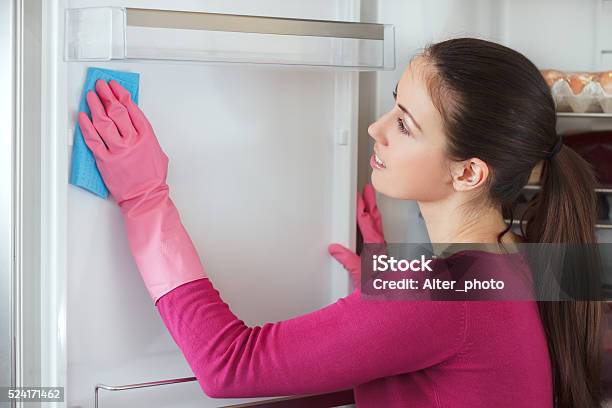 Young Woman Cleaning Refrigerator With Rag At Home Stock Photo - Download Image Now - Empty, Refrigerator, Women