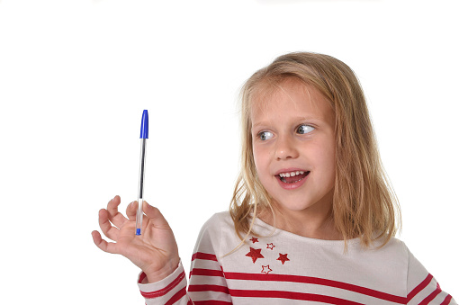 sweet beautiful female child 6 to 8 years old with cute blonde hair and blue eyes holding ballpoint pen isolated on white background in education and primary or junior school supplies concept