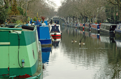 Live-aboard barges moored on Regent's Canal in London UK