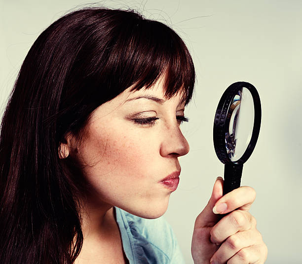 istock That doesn't look good! Disapproving woman with magnifying glass 524175177