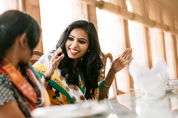 Young Indian Women Dining Together Young Indian women dining together in restaurant women only restaurant stock pictures, royalty-free photos & images