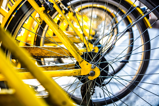 Yellow bike's wheel in row outdoor. Close-up.