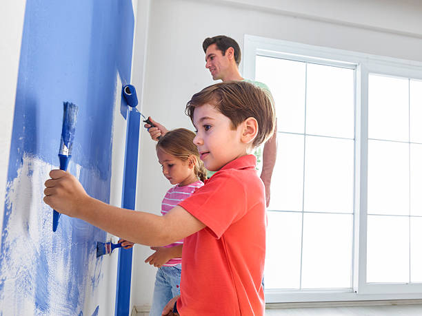 istock Father and childs painting wall 524178704