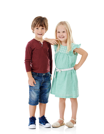 Studio shot of a cute little boy and girl posing together against a white background